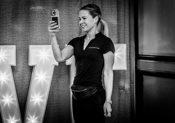 Gail Irvine - owner of Content by Gail, a Scottish wedding content creator - smiles as she snaps a picture at a wedding.